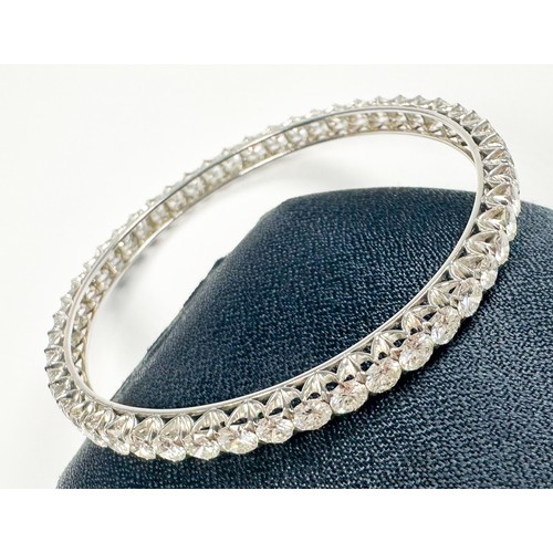 295 - An 18ct white gold diamond bangle, claw set with 50 x round brilliant cut diamonds, estimated total ... 