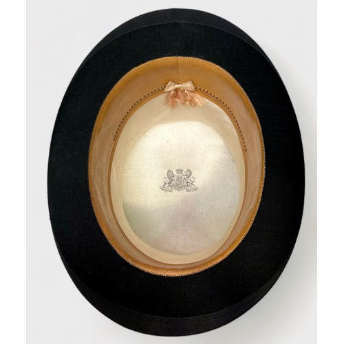 360 - A vintage top hat with coat of arms to interior, housed in fitted and lined tan leather, lockable tr... 