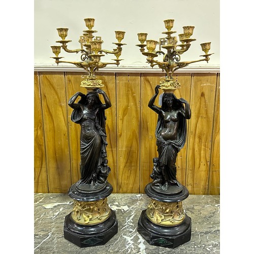 496 - A pair of bronze and ormolu figural seven-light candelabra, each cast with a classical maiden suppor... 