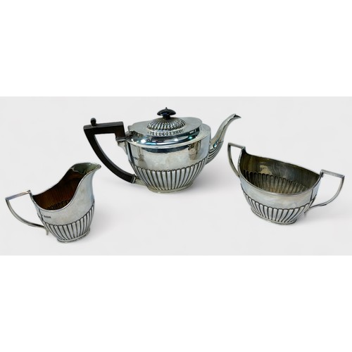 90 - An Edwardian three-piece silver tea-set by Martin, Hall & Co. of oval form with vertical half-reeded... 