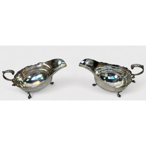 89 - A pair of Edwardian silver sauce boats by Robert Stebbings, of typical oval bellied form and raised ... 