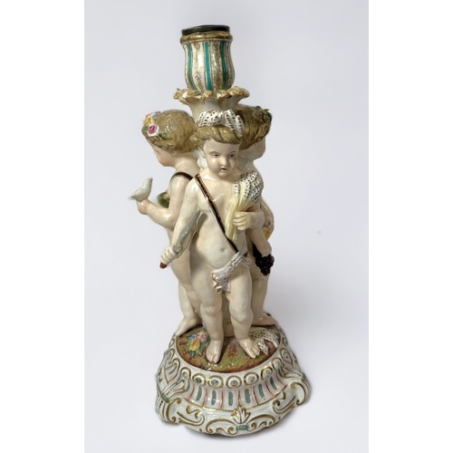 31 - A 19th century continental porcelain figural candlestick, modelled with three Putti emblematic of th... 