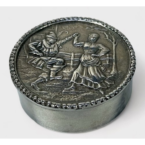 110 - An Elizabeth II silver snuff box, of circular form, the hinged lid decorated in relief with a scene ... 