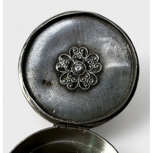 110 - An Elizabeth II silver snuff box, of circular form, the hinged lid decorated in relief with a scene ... 