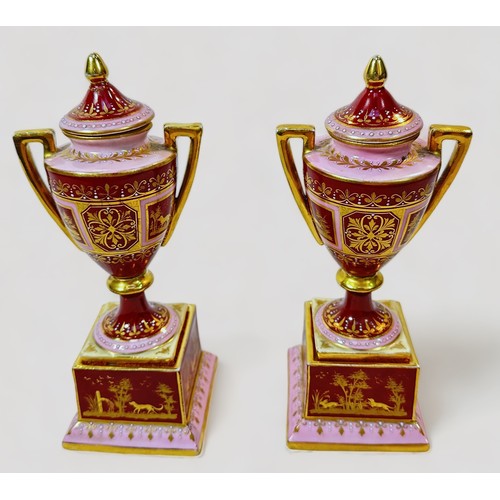 37 - A pair of 19th century Viennna Porcelain pedstal vases and covers, with rouge grounds and pink bands... 