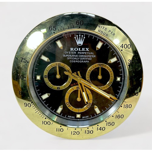 135 - A Rolex authorised dealer display wall clock, modelled as a Rolex Daytona, the black dial with gilt ... 