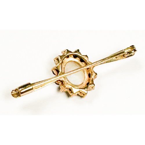 173 - A 9ct gold bar-brooch, claw set to the centre with an oval-shaped opal, surrounded by 12 x round fac... 