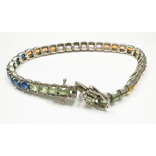 200 - A silver tennis bracelet, claw-set with various coloured gemstones, including blue sapphires, pink s... 