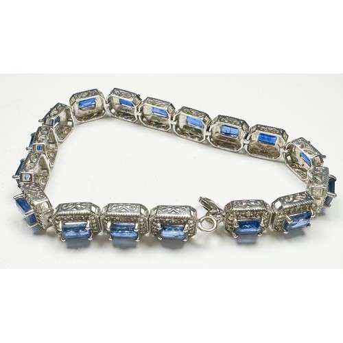 201 - A silver bracelet, set with 17 x rectangular shaped sapphires, each sapphire claw-set with small dia... 