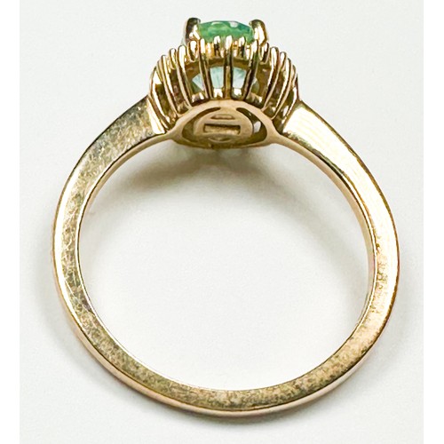 218 - A 9ct yellow gold dress ring, claw set to the centre with an oval shaped emerald, surrounded by 29 x... 