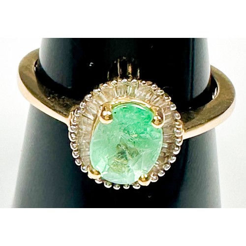 218 - A 9ct yellow gold dress ring, claw set to the centre with an oval shaped emerald, surrounded by 29 x... 