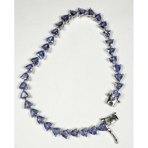 235 - A silver bracelet, claw set with 34 x trilliant-cut tanzanite gemstones, weighing approximately 11.0... 