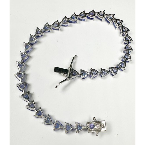 235 - A silver bracelet, claw set with 34 x trilliant-cut tanzanite gemstones, weighing approximately 11.0... 