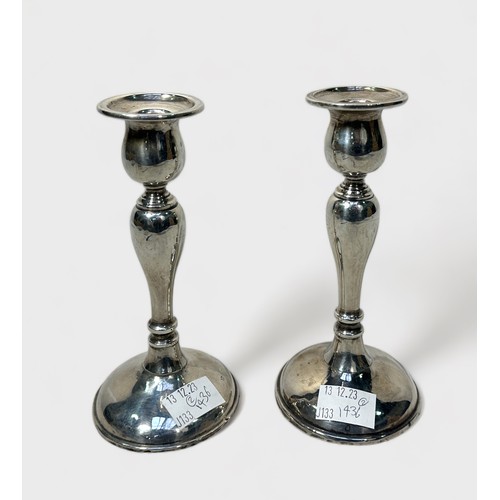 115 - A pair of silver candlesticks of inverted baluster form, with loaded bases, 18cm high, British hallm... 