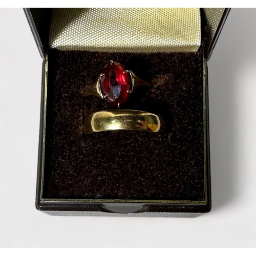 249 - Two 9ct gold rings, including a wedding band and one set with an oval faceted ruby coloured stone, g... 