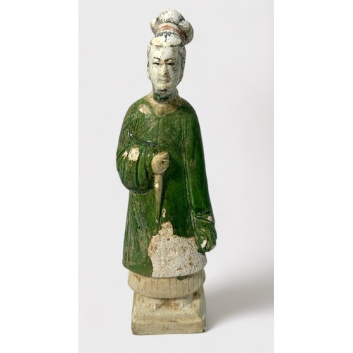 84 - A Chinese Ming Dynasty earthenware tomb figure wearing a green flowing robe, raised on pedestal, 18c... 