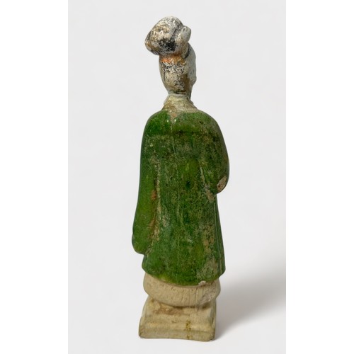 84 - A Chinese Ming Dynasty earthenware tomb figure wearing a green flowing robe, raised on pedestal, 18c... 