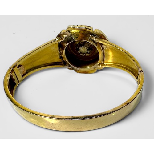 267 - A yellow metal, tests as 14ct gold or above hinged bangle, with decorative top modelled as a stylise... 