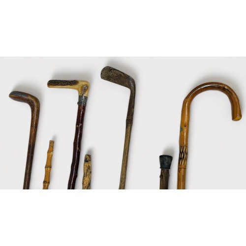 450 - Seven various vintage walking sticks, comprising, two golf Sunday walking sticks, a wooden example w... 