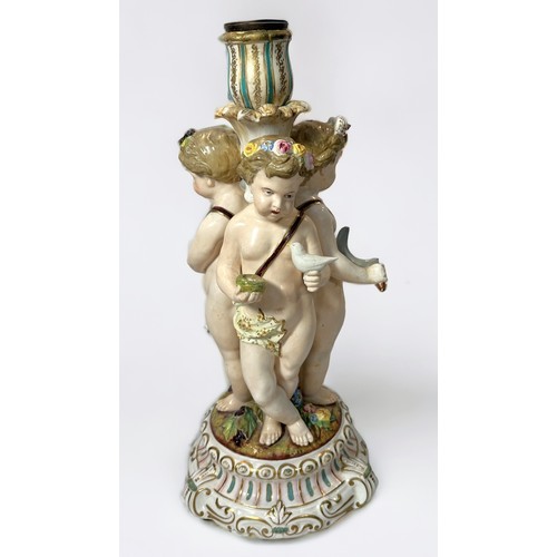 7 - A 19th century continental porcelain figural candlestick, modelled with three Putti emblematic of th... 
