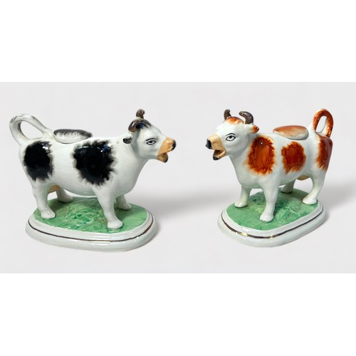 10 - A pair of 19th century pottery cow creamers, with removable covers, raised on naturalistic oval base... 