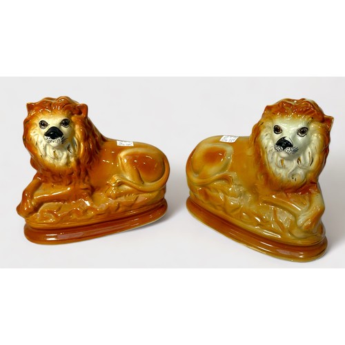 29 - Two pairs of Victorian Staffordshire pottery mantel figures, including recumbent lions with glass ey... 