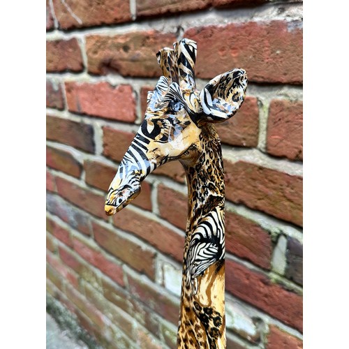 476 - A model of a giraffe by ‘Collage’, with printed safari decoration, raised on naturalistic base, 101c... 