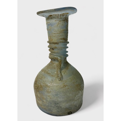 32 - A Roman clear glass bottle, or unguentarium, flared rim and tapering funnel neck to bulbous body, sp... 