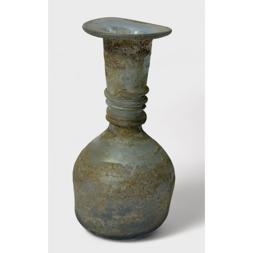 32 - A Roman clear glass bottle, or unguentarium, flared rim and tapering funnel neck to bulbous body, sp... 