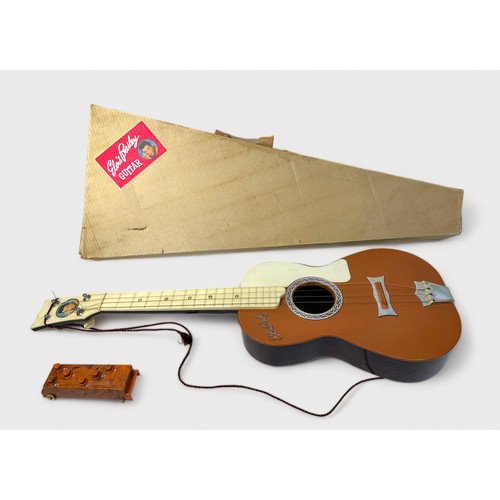 543 - A vintage Elvis Presley toy guitar by Selcol, the brown, cream and burgundy plastic four string guit... 