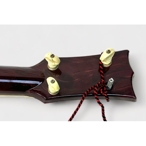 543 - A vintage Elvis Presley toy guitar by Selcol, the brown, cream and burgundy plastic four string guit... 