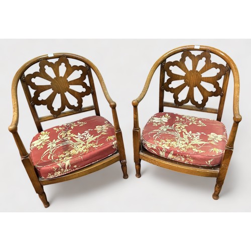 700 - A pair of early 20th Century low mahogany tub chairs, pierced flower back, red floral upholstered cu... 