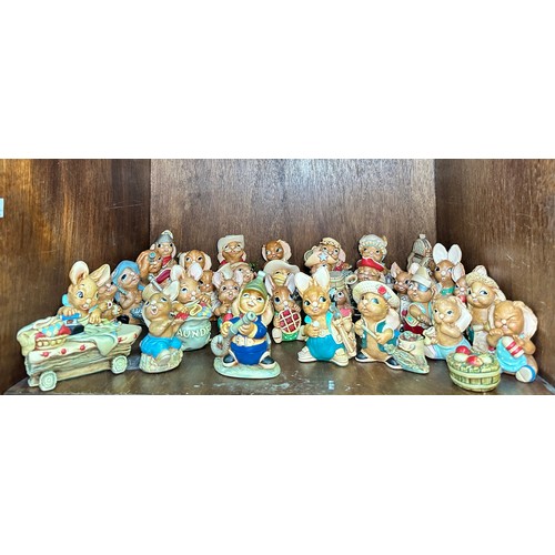 63 - A large collection of Pendelfin Rabbits, including rabbit figures and several display stands, approx... 
