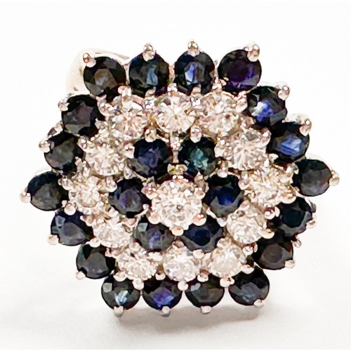 192 - An 18ct white gold dress ring, claw-set with 24 x round-shaped dark blue sapphires, and 13 x round b... 