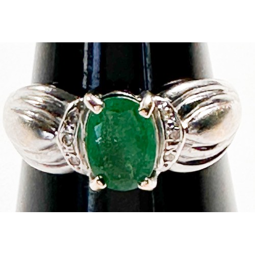 239 - A 14ct white gold dress ring, four claw set with an oval shaped emerald to the centre, measuring 7mm... 