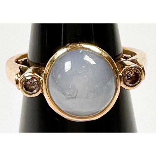 193K - An 18ct yellow gold dress ring, set with a round shaped grey star sapphire, bezel set with a round d... 