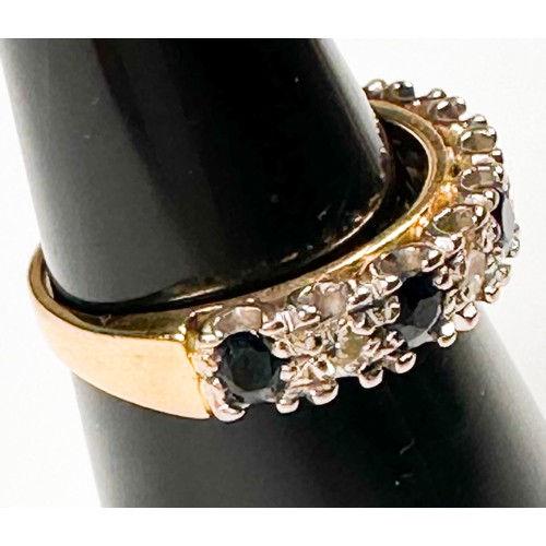 237 - An 18ct yellow gold half-hoop ring, multi-claw set with five dark blue sapphires, and four round bri... 