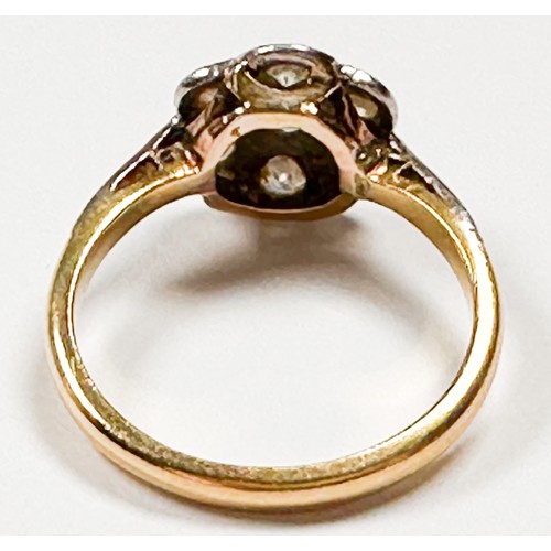 193C - An 18ct yellow gold cluster ring, set with seven round diamonds in a white gold star and daisy desig... 