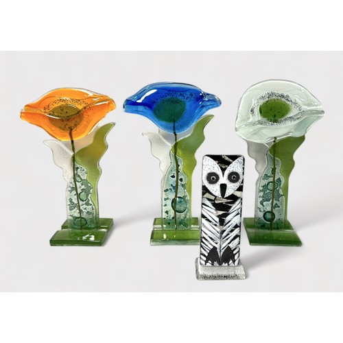 67 - Three stylised fused glass standing flowers by  Anita Pawlowska, 24cm high, another similar figure o... 