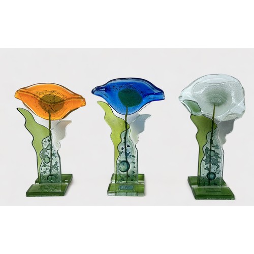 67 - Three stylised fused glass standing flowers by  Anita Pawlowska, 24cm high, another similar figure o... 