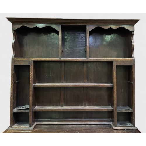 703 - An 18th century and later oak dresser, the later raised back section with shaped cornice, above shel... 