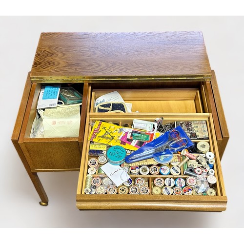 382 - A 1960s oak laminate sewing table, of rectangular form on trestle supports, with piano-hinged top en... 