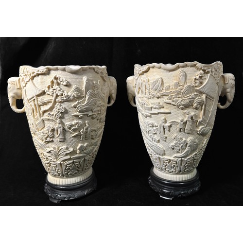 72 - A pair of Chinese two-handled resin vases, each decorated in relief with figures in a landscape with... 