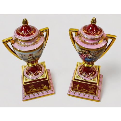 79 - A pair of 19th century Viennna Porcelain pedstal vases and covers, with rouge grounds and pink bands... 