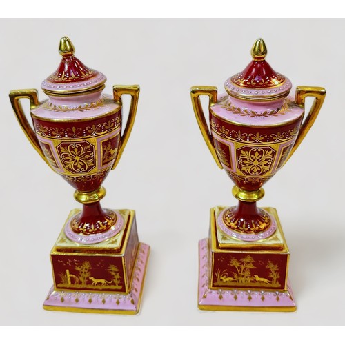 79 - A pair of 19th century Viennna Porcelain pedstal vases and covers, with rouge grounds and pink bands... 