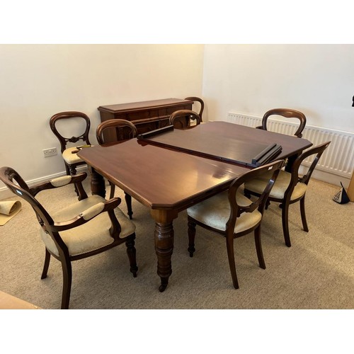 706 - A large Victorian mahogany dining table, two leaves, canted corners, raised on four turned supports ... 