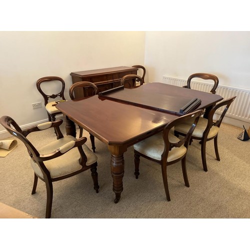 706 - A large Victorian mahogany dining table, two leaves, canted corners, raised on four turned supports ... 