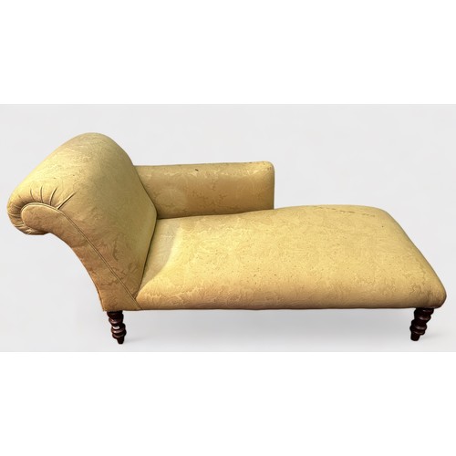 707 - A Victorian-style chaise longue, with cream foliate upholstery and matching bolster cushion, on turn... 