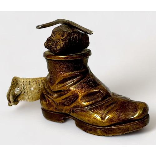 348 - A Novelty Gilt Brass Tape Measure modelled as a Hobnail Boot with a rock and walking stick balanced ... 