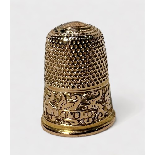 396 - An Edwardian 15ct gold thimble, typical dimled crown and skirt with foliate chased snd ebngraved low... 